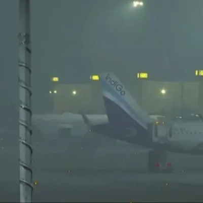 he thick layer of fog enveloping Delhi, causing disruptions in flight and train services, symbolizing the challenging weather conditions in the city.