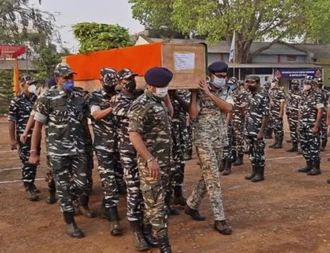 A somber image depicting security personnel in Bastar, Chhattisgarh, amid the aftermath of a tragic clash with Maoists. The image reflects the challenges faced in conflict-prone regions.
