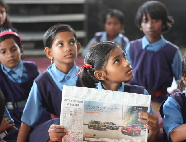 A group of diverse students studying together in a rural school setting.