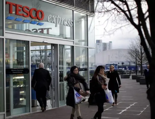 Tesco storefront adorned with Christmas decorations, showcasing a bustling and festive atmosphere during the holiday season.