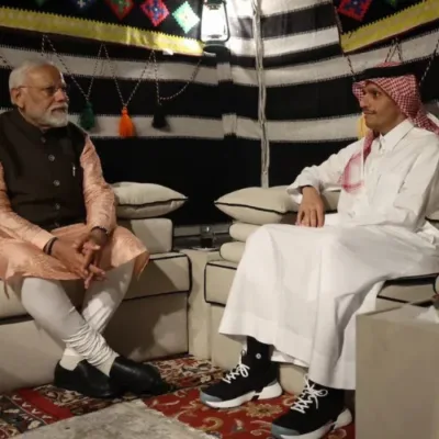 Prime Minister Modi and Sheikh Al Thani shaking hands in Qatar, symbolizing strengthened ties.