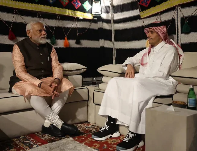 Prime Minister Modi and Sheikh Al Thani shaking hands in Qatar, symbolizing strengthened ties.
