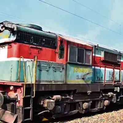Runaway train in India stopped on tracks, railway officials in background.