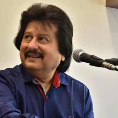 Close-up portrait of Pankaj Udhas singing with a microphone.
