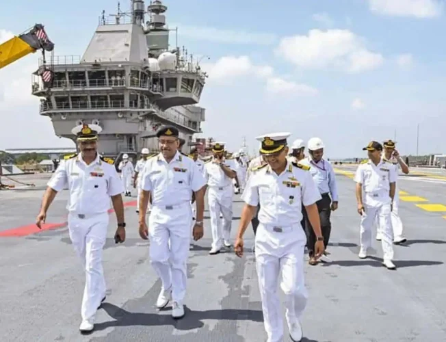 Eight smiling Indian Navy veterans standing together, celebrating their release from prison in Qatar.