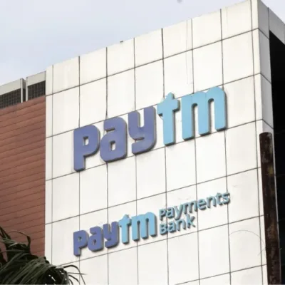 Paytm stock chart with downward trend and RBI logo, symbolizing impact of regulations.