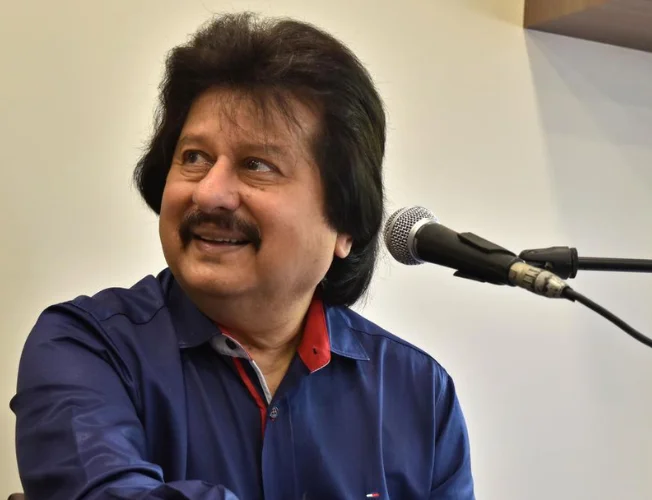 Close-up portrait of Pankaj Udhas singing with a microphone.