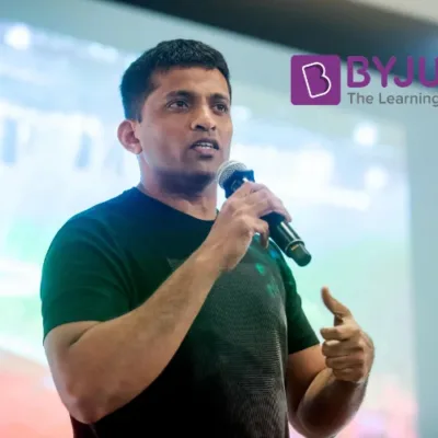 BYJU’S logo on a digital tablet with a valuation chart in the background.