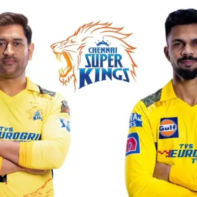 Ruturaj Gaikwad holding the CSK team jersey, with the team logo in the background.