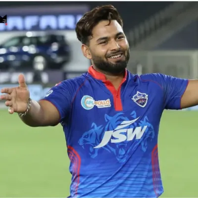 Rishabh Pant, wearing the Delhi Capitals uniform, strides confidently onto the cricket field, symbolizing his triumphant return to the sport after overcoming a challenging injury setback.