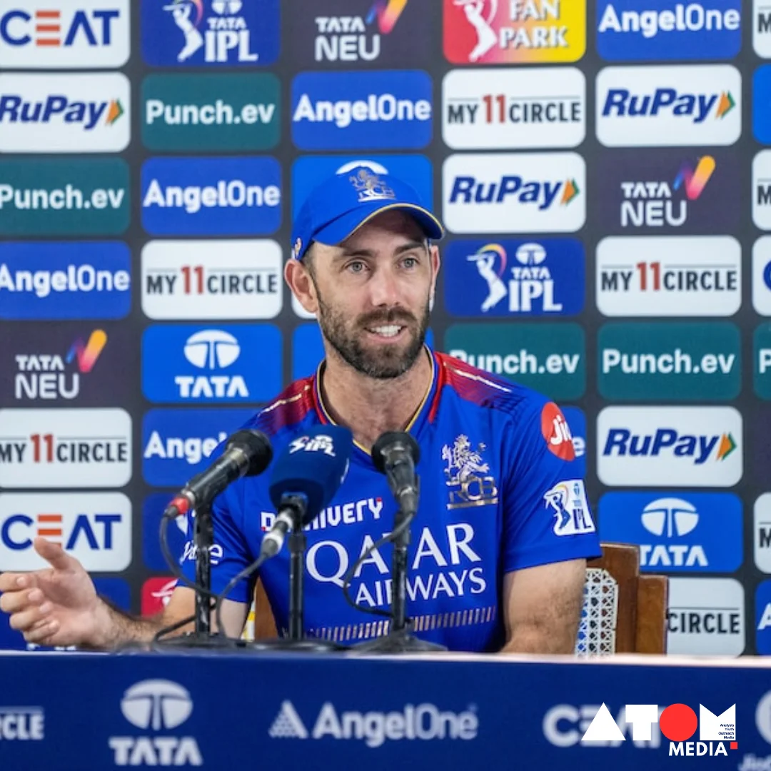 Glenn Maxwell, wearing his cricket gear, stands behind a podium addressing reporters during a press conference regarding his decision to take an indefinite break from IPL 2024 due to mental and physical fatigue.