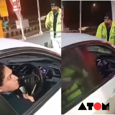 The image shows a screengrab from the viral video depicting the moment a Pakistani woman attempts to run over a traffic police officer with her car after an argument.