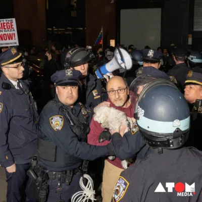 A group of New York City police officers erect barricades outside Hamilton Hall at Columbia University while pro-Palestinian supporters demonstrate in the background. (Photo by SPENCER PLATT / GETTY IMAGES NORTH AMERICA / Getty Images via AFP)