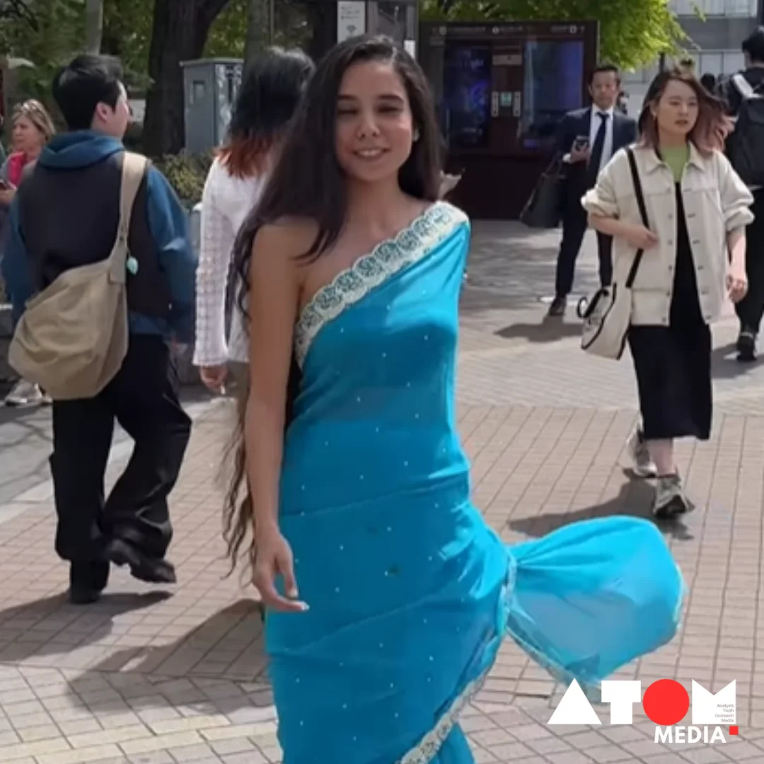 Indian woman in blue saree walking on streets of Japan, capturing attention of passersby.