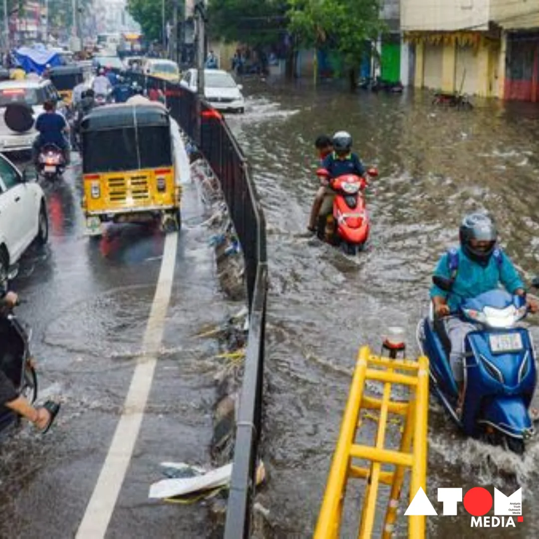 Heavy rainfall causing flooding in a street in Kerala, with people wading through water