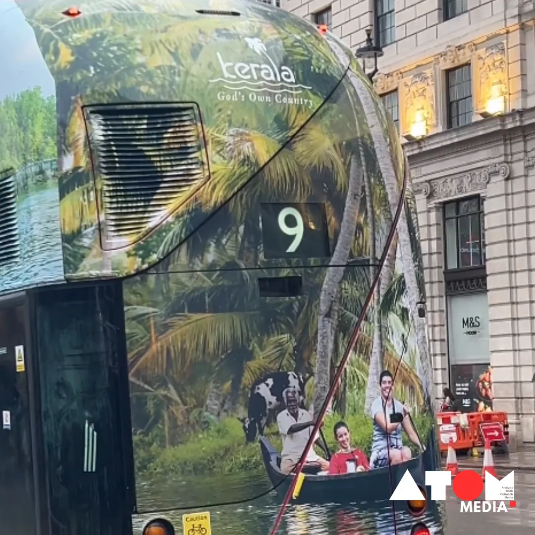 The image showcases a red double-decker bus in London adorned with vibrant advertisements promoting Kerala Tourism. Passersby pause to admire the captivating display, featuring images of Kerala's lush landscapes and serene backwaters. This visual spectacle has garnered widespread attention on social media platforms, sparking appreciation for Kerala's natural beauty.