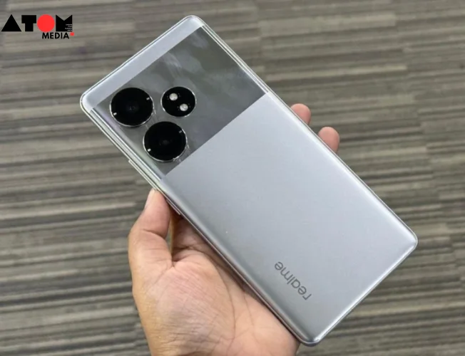 Realme GT 6T smartphone in two colors (Fluid Silver and Razor Green) with the display showcasing a vibrant game scene.