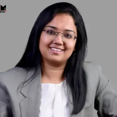 A professional headshot of Mrinalini Srinivasan superimposed on a background with the P&G logo.