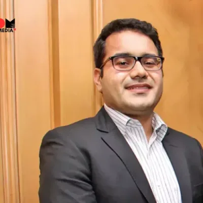 A group of young Indian entrepreneurs discussing business strategies in a modern office setting.