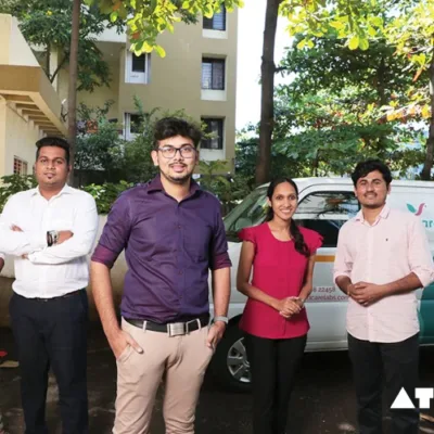 A group of investors from Shark Tank India sitting around a table with a young entrepreneur presenting his product.