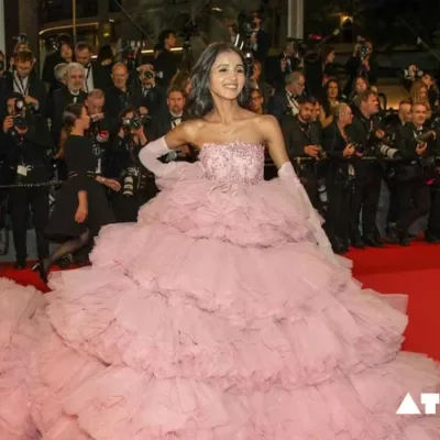 A group of social media influencers posing for photos on the red carpet at the Cannes Film Festival. Some wear designer gowns and tuxedos, while others have more casual attire.