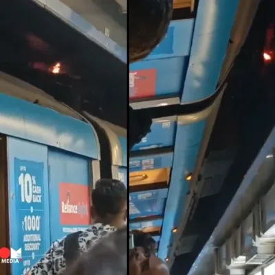 A Delhi Metro train with a pantograph extended towards the overhead electrical wires.