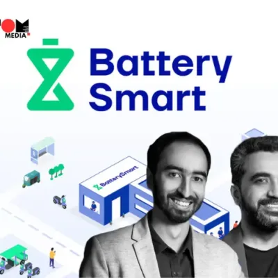 Battery Smart employees and e-rickshaw drivers at a battery-swapping station in an urban setting.